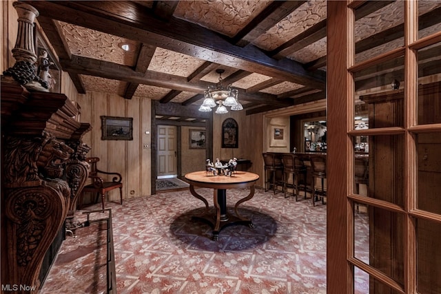 wine area featuring wooden walls, ceiling fan, beam ceiling, and coffered ceiling