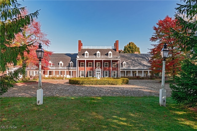 view of front of house with a balcony and a front yard