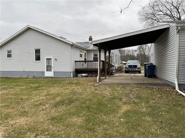 exterior space featuring a carport, a yard, and a wooden deck