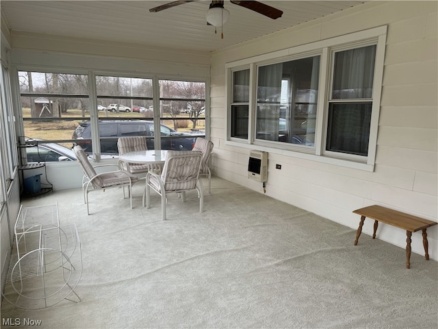 sunroom featuring heating unit and ceiling fan