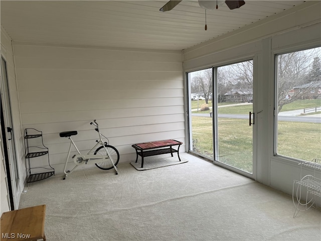 unfurnished sunroom featuring ceiling fan and a wealth of natural light