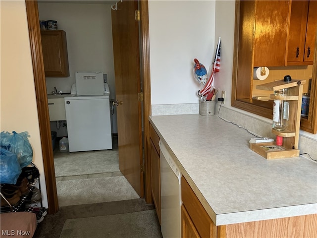 kitchen featuring dishwasher, sink, and washer / dryer