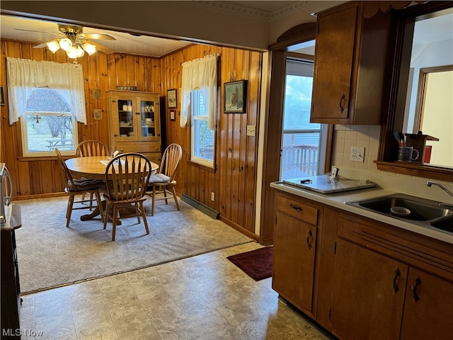 kitchen featuring a healthy amount of sunlight, wooden walls, and tasteful backsplash