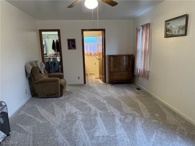 sitting room with ceiling fan and light colored carpet