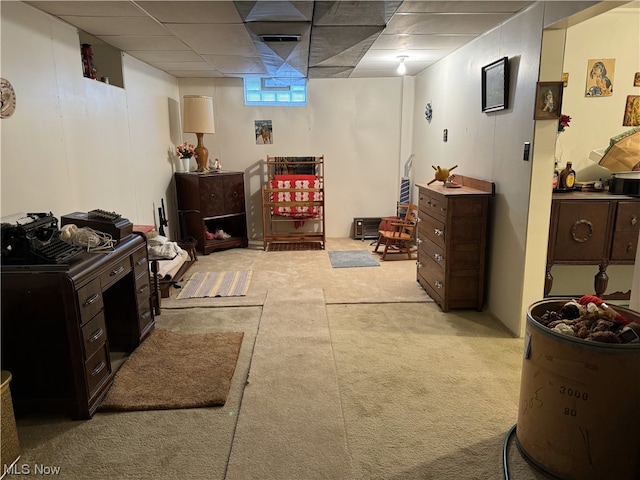 basement featuring light colored carpet and a drop ceiling