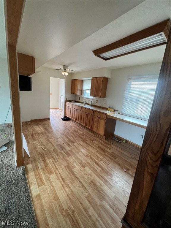 unfurnished living room with plenty of natural light, ceiling fan, and light wood-type flooring