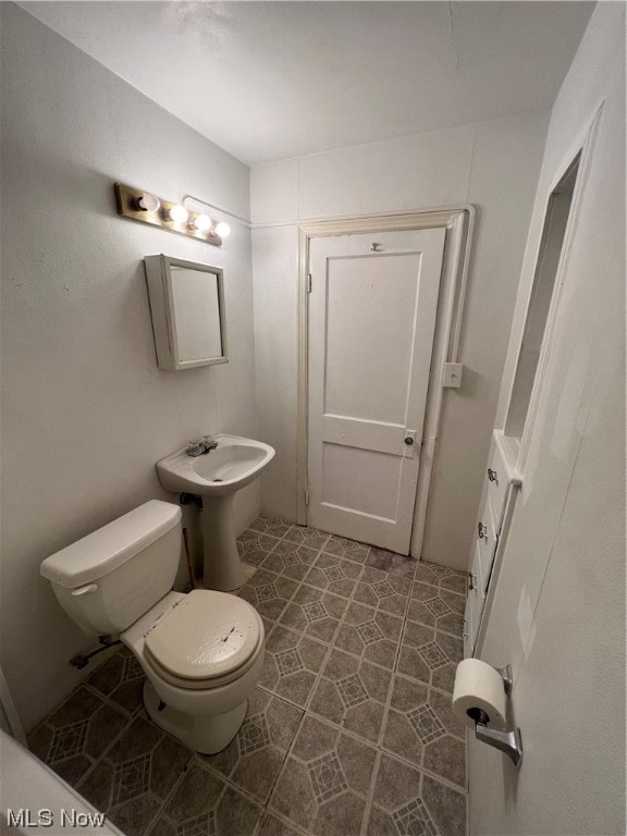 bathroom featuring toilet and tile patterned flooring