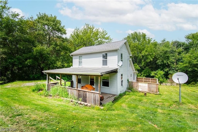 rear view of property featuring a deck and a lawn