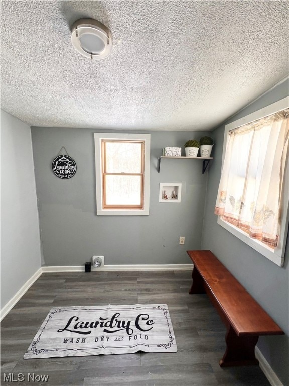 laundry area with hookup for a washing machine, a textured ceiling, plenty of natural light, and dark hardwood / wood-style floors