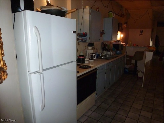 117A High St, Flushing, OH 43977 - kitchen with white appliances, tile patterned floors, light countertops, and a peninsula