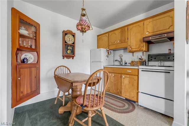 kitchen featuring sink, hanging light fixtures, and white appliances