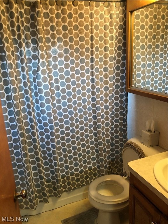 bathroom featuring vanity, toilet, a shower with shower curtain, and tile walls