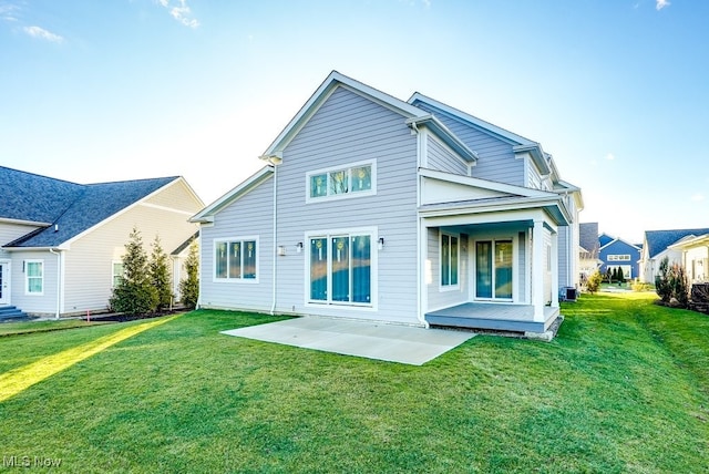 back of house featuring a patio area and a lawn