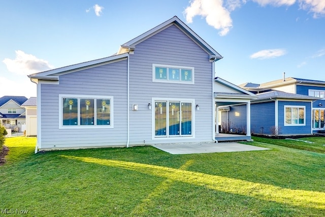 back of house featuring a lawn and a patio area