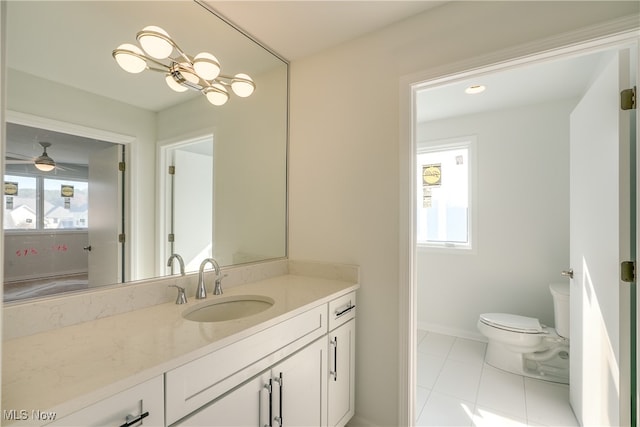 bathroom with toilet, vanity, and tile patterned floors