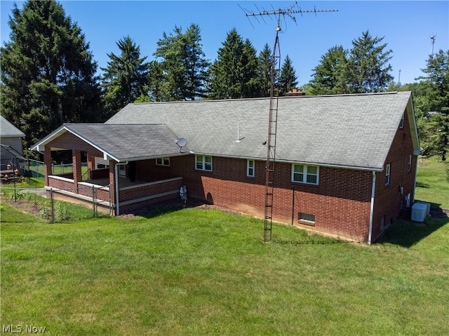 rear view of property featuring a yard