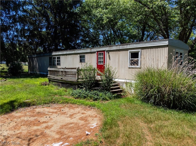 manufactured / mobile home with a front lawn and a wooden deck