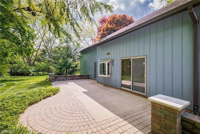 view of property exterior with a lawn and a patio