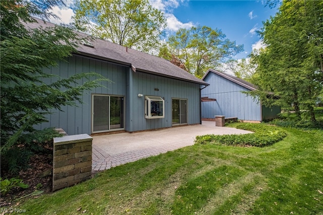 back of property featuring a lawn and a patio area