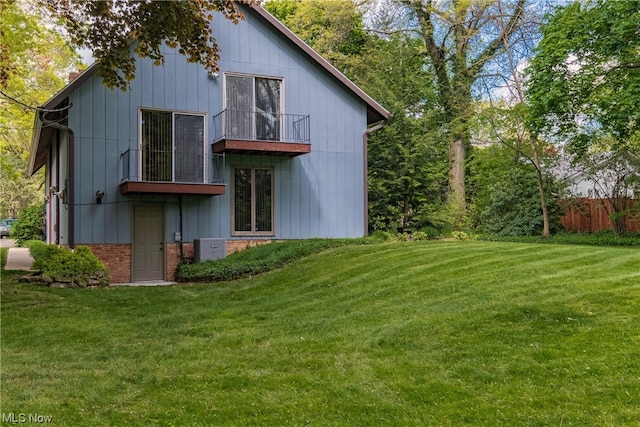 back of house featuring a yard and a balcony