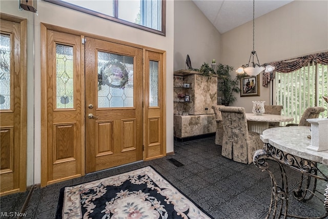 tiled foyer featuring high vaulted ceiling