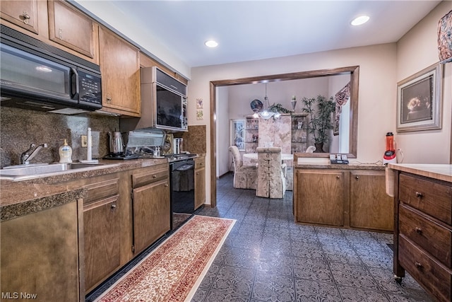 kitchen with black appliances, sink, dark tile flooring, tasteful backsplash, and pendant lighting