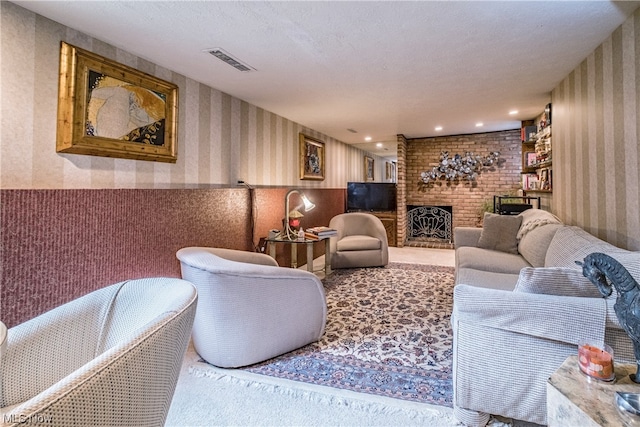 living room featuring light carpet, a brick fireplace, and a textured ceiling