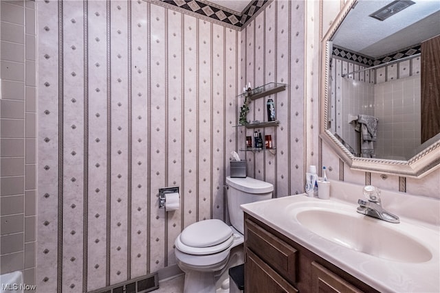 bathroom featuring tile flooring, toilet, oversized vanity, and a textured ceiling