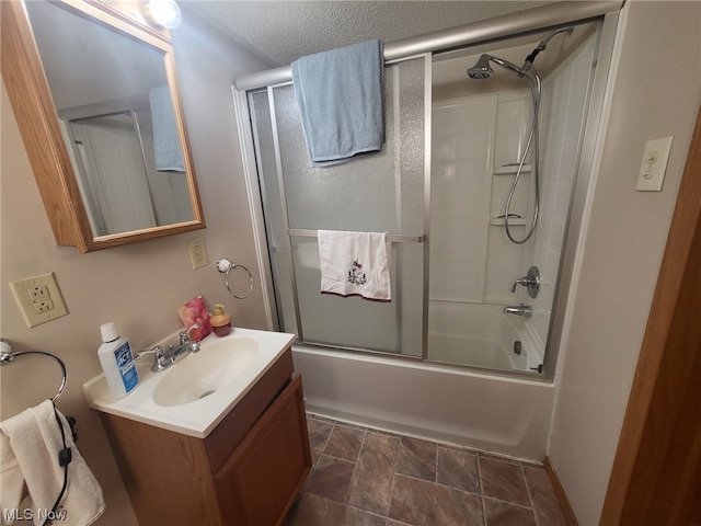 bathroom with shower / bath combination with glass door, a textured ceiling, and vanity