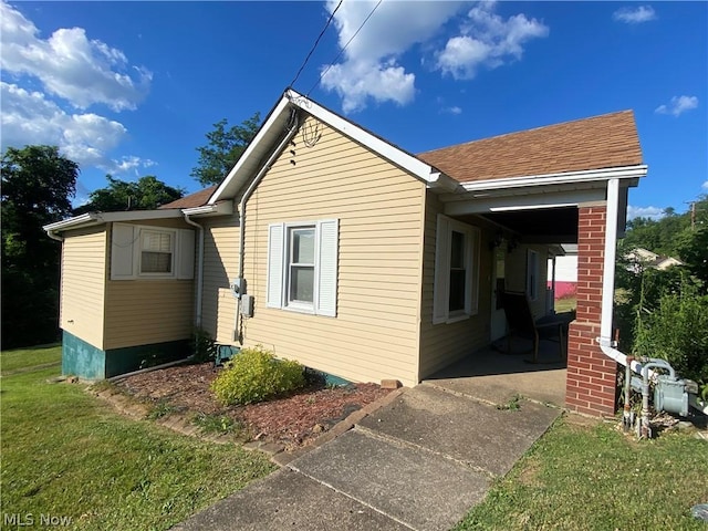 view of property exterior with a yard and a carport