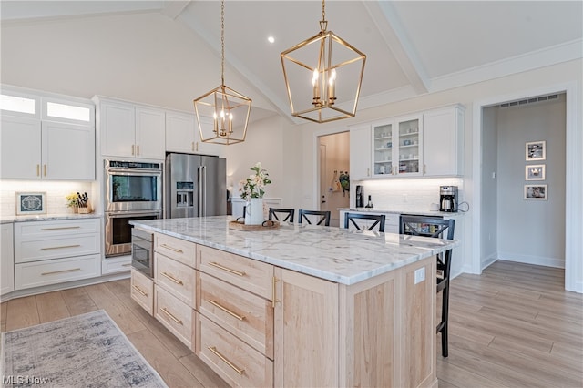 kitchen with appliances with stainless steel finishes, tasteful backsplash, and beamed ceiling