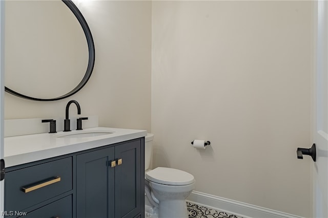 bathroom with toilet, vanity with extensive cabinet space, and tile floors