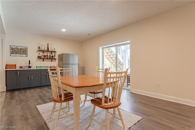 dining area with a textured ceiling, dark hardwood / wood-style floors, and sink