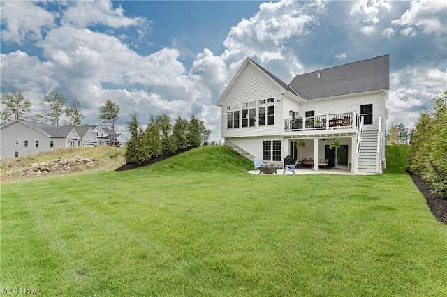 back of property with a wooden deck, a patio area, and a yard