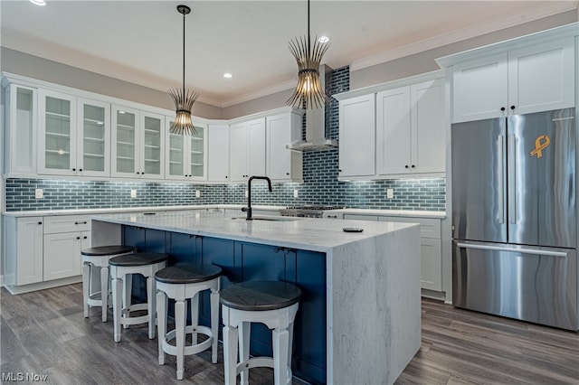 kitchen with backsplash, white cabinetry, stainless steel refrigerator, and decorative light fixtures