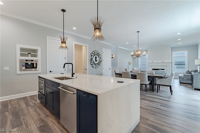 kitchen featuring dark hardwood / wood-style flooring, sink, stainless steel appliances, and a large fireplace