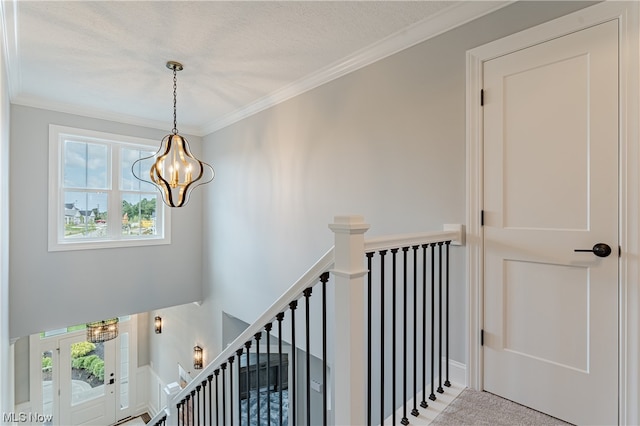 stairway with ornamental molding and a notable chandelier