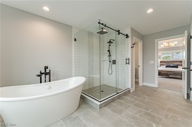 bathroom featuring shower with separate bathtub, a chandelier, and tile floors