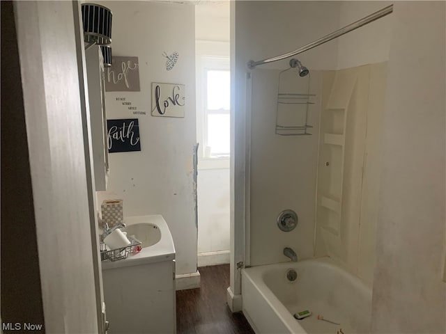 bathroom featuring shower / washtub combination, wood-type flooring, and sink