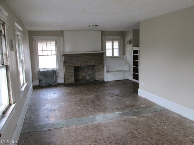 unfurnished living room with a fireplace and a textured ceiling