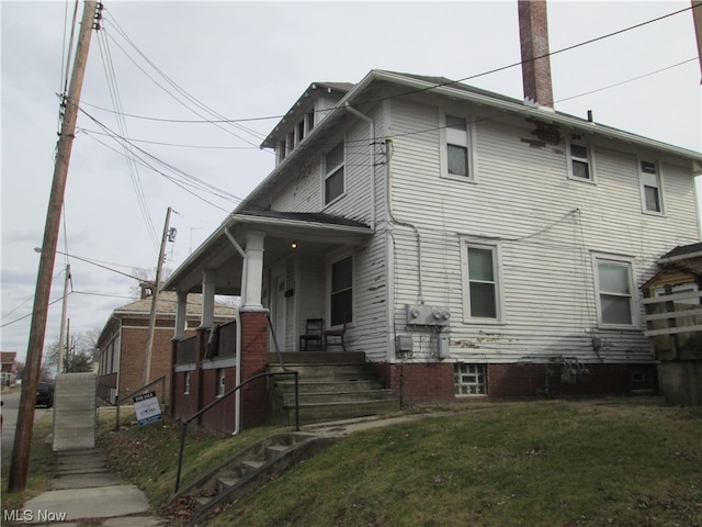 back of house with a porch and a lawn