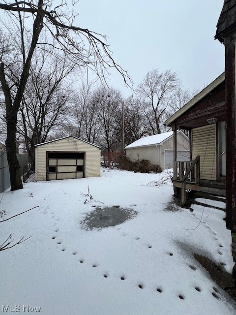 yard covered in snow featuring a garage