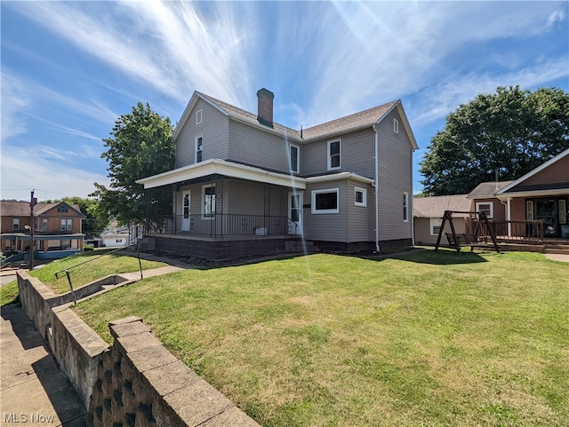 rear view of property featuring a porch and a yard