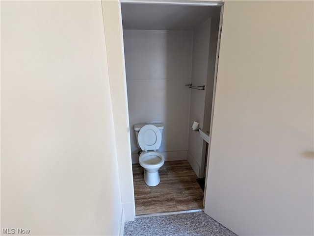 bathroom featuring toilet and wood-type flooring