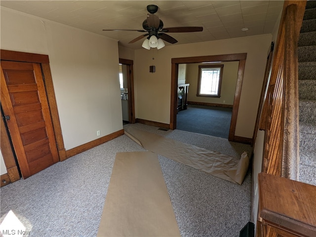 unfurnished bedroom featuring dark colored carpet and ceiling fan