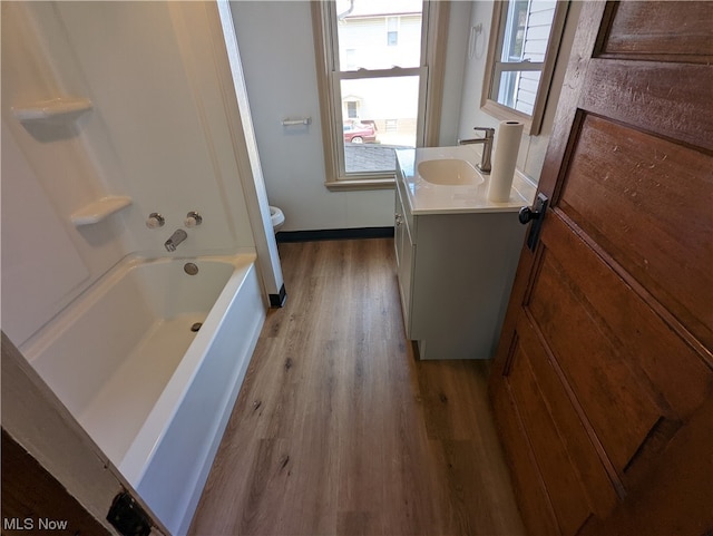 full bathroom with vanity, wood-type flooring, shower / bathing tub combination, and toilet