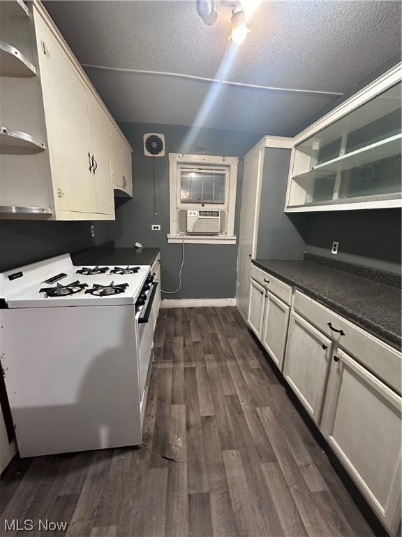 kitchen featuring dark wood-type flooring, cooling unit, white gas range, and a textured ceiling