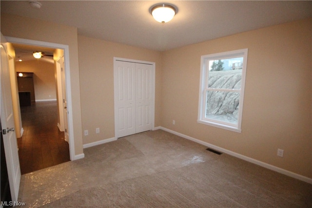 unfurnished bedroom featuring carpet flooring and a closet