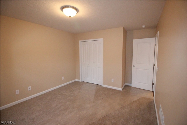 unfurnished bedroom featuring a closet and light carpet