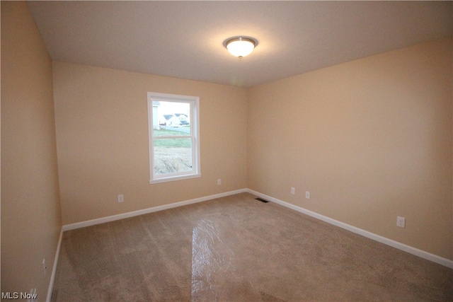 unfurnished room with dark colored carpet